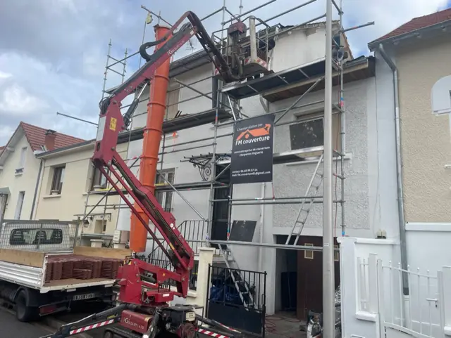 Façade d'immeuble sous échafaudage complet avec nacelle élévatrice pour travaux de toiture