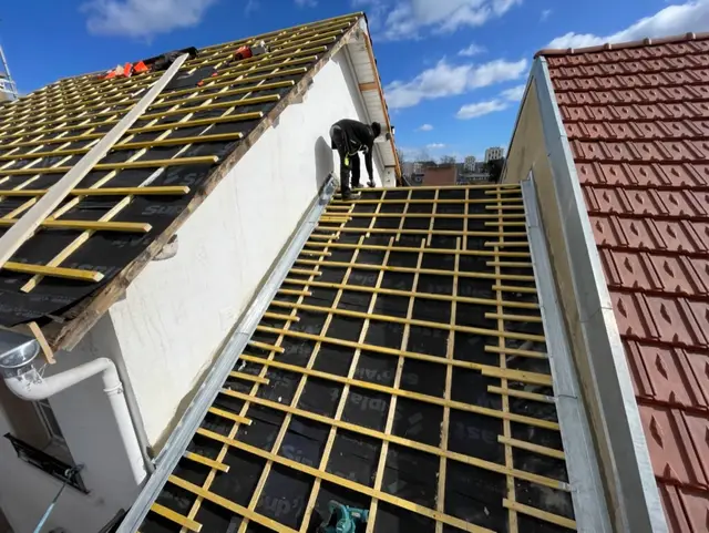 Charpente avec liteaux et écran de sous-toiture fraîchement posés, avant couverture en tuiles