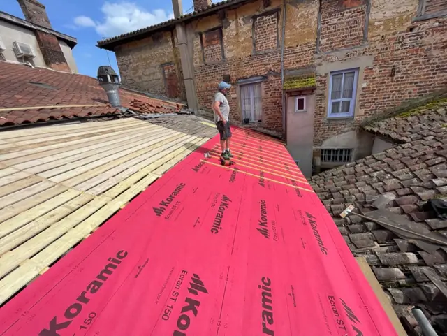 Écran d'étanchéité rouge posé sur la charpente avant couverture en tuiles