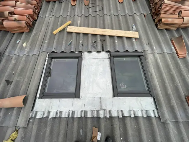 Pose de deux fenêtres de toit Velux sur une toiture en bac acier avant couverture