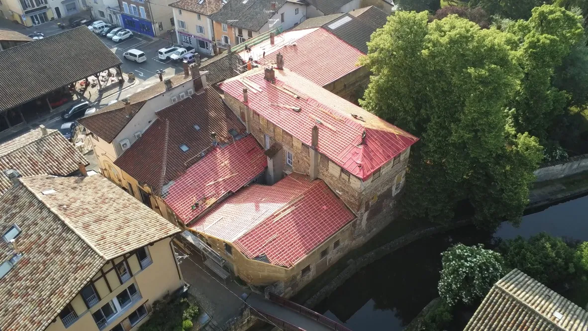 Vue aérienne d'une toiture en tuiles canal en cours de réfection dans le centre-ville