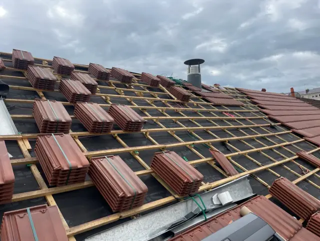 Détail d'une toiture en tuiles terminée avec sortie de cheminée et tuiles de ventilation