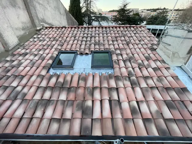 Toiture en tuiles terminée avec deux fenêtres de toit Velux intégrées